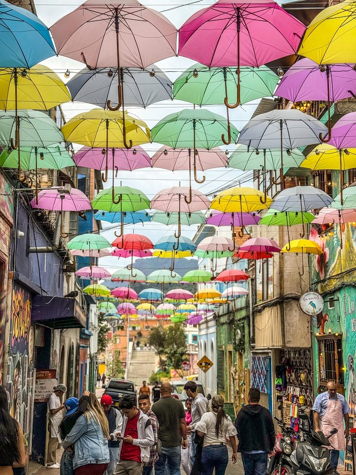 Calle con sombrillas de colores en un barrio de Colombia